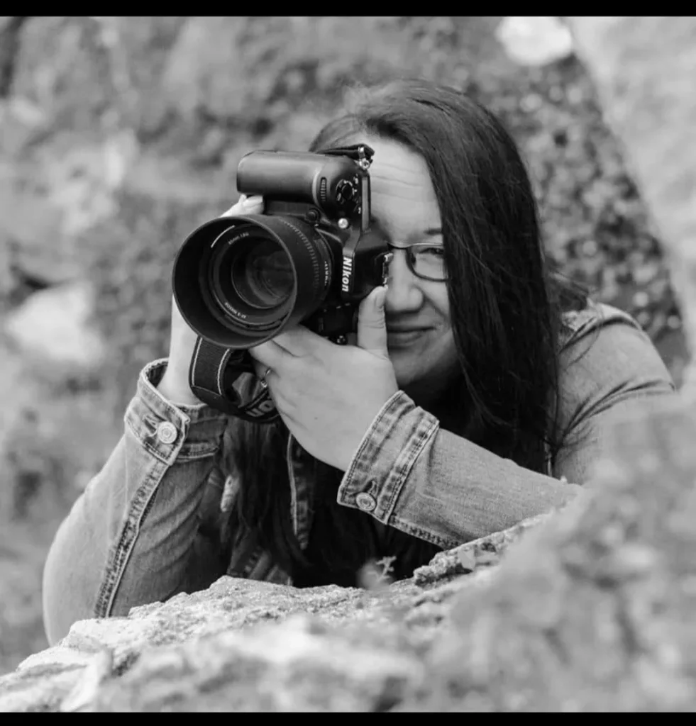 Photographer with camera capturing nature in black and white.