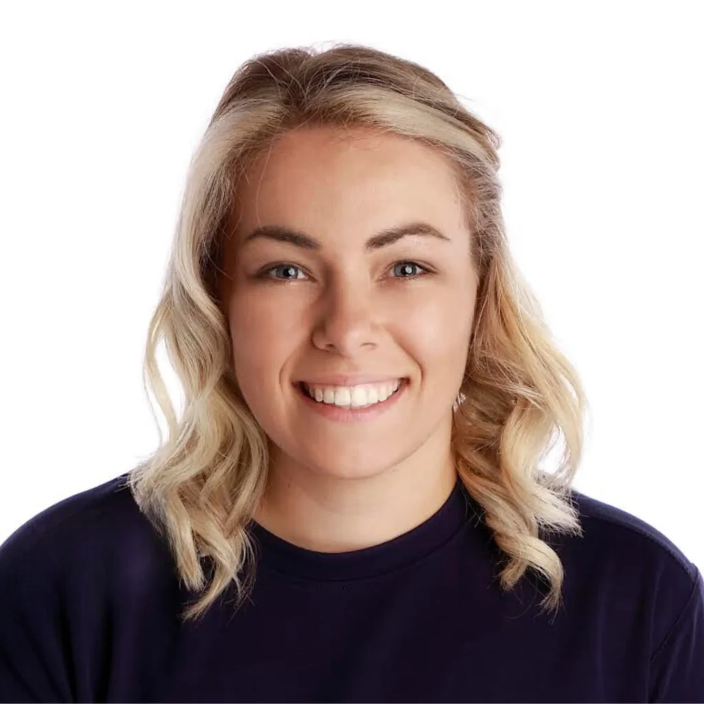 Smiling woman with blonde hair and black shirt on white background.